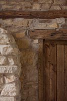Mur en pierres apparentes et poutres sur porte