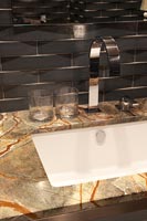 Carrelage de style brique dans une salle de bain moderne avec contour en marbre sur lavabo