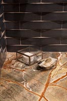 Carrelage de style brique dans une salle de bain moderne avec des accessoires sur une surface en marbre
