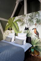 Scène tropicale peinte comme toile de fond au lit dans une chambre moderne