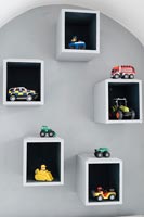 Étagères de boîte avec des voitures et des jouets affichés