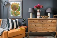 Chaise en cuir orange et buffet en bois dans le salon avec des murs gris foncé