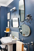 Affichage des miroirs sur mur peint en bleu foncé dans la salle de bain lassique