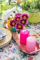 Fleurs roses et bougies sur table avec nappe florale