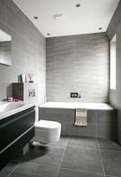 Salle de bain moderne avec carrelage gris au sol et aux murs