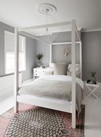 Lit à baldaquin blanc dans une chambre moderne avec des murs peints en gris