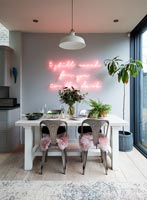 Néon rose sur le mur caractéristique au-dessus de la table à manger