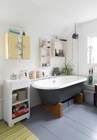Salle de bain moderne avec baignoire grise et sol peint assorti