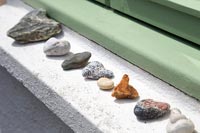 Rangée de galets et de pierres sur le rebord de la fenêtre extérieure