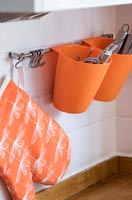 Porte-couverts orange sur le mur de la cuisine