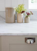 Pots en terre cuite sur un plan de travail en marbre dans une cuisine de style rustique moderne