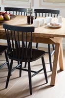 Chaises peintes en noir à côté d'une table en bois
