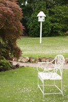 Pigeonnier et chaise dans jardin de campagne
