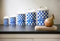 Rangée de pots de rangement bleu et blanc sur le plan de travail de la cuisine