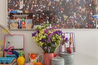 Arrangement de fleurs sur meuble de cuisine avec grande photographie derrière