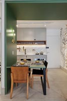 Cadre en bois vert avec table à manger intégrée et vue sur la cuisine