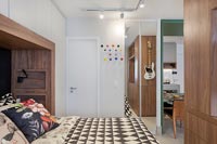 Chambre moderne avec vue sur la salle à manger et la cuisine dans un appartement décloisonné