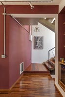 Couloir et escaliers avec des murs peints en rouge foncé