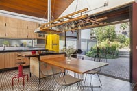 Cuisine-salle à manger industrielle moderne avec portes pliantes donnant sur le jardin