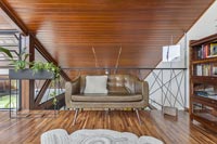 Canapé en cuir dans le salon moderne avec plafond en bois incliné