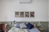 Chambre moderne avec groupe de peintures au-dessus du lit