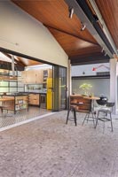 Espace barbecue sur terrasse à l'extérieur de la cuisine avec portes coulissantes ouvertes