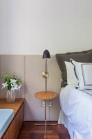 Petite table de chevet et lampe avec tête de lit rembourrée