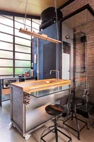 Cuisine industrielle moderne avec mur de briques apparentes et cabine de douche