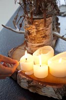 Bougies d'éclairage à la main sur socle en bois naturel
