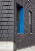 Bâtiment noir avec encadrement de fenêtre aux couleurs vives