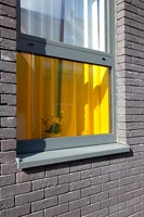Bâtiment en brique grise avec des fenêtres en verre coloré