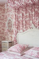 Chambre rose et blanche avec auvent en tissu et papier peint