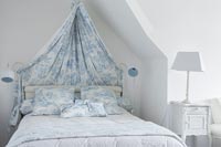 Ciel de lit en tissu bleu et blanc avec coussins assortis