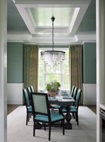 Salle à manger moderne avec chaises turquoise et lustre élégant