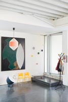 Couloir contemporain avec sol en béton poli et œuvres d'art modernes