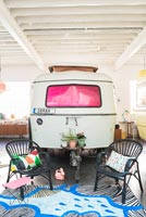 Caravane vintage et coin salon dans la chambre industrielle pour enfants