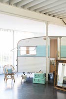 Caravane vintage utilisée comme chambre à coucher dans une maison industrielle