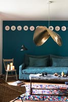 Suspension inhabituelle dans un salon moderne avec des murs bleu foncé