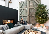Femme lisant dans un salon de campagne moderne décoré pour Noël