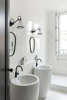 Lavabos doubles dans la salle de bain blanche moderne avec robinets noirs et cadres de miroir