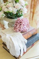 Gants en dentelle et rose rose vintage sur une pile de vieux livres