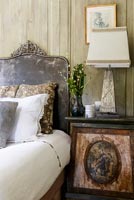 Tête de lit en velours dans une chambre classique avec table d'appoint et lampe ornées