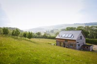 Maison en bois à flanc de colline avec vue sur la campagne