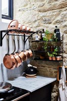 Pots de cuivre sur rack de stockage dans la cuisine moderne