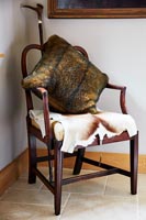 Coussin en fourrure et peau d'animal sur fauteuil en bois
