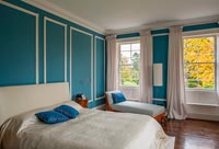 Chambre des maîtres avec mur lambrissé peint en bleu