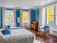 Chambre classique avec murs lambrissés peints en bleu