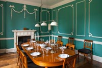 Salle à manger classique avec des murs lambrissés verts et blancs