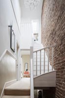 Palier moderne à l'étage, escalier et briques apparentes