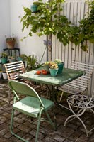 Petite table de café verte et chaises sur terrasse